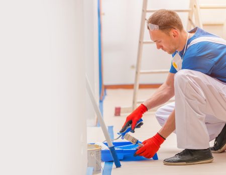 House Walls Painting. Young Caucasian Men Painting His Home. Construction and Renovation.